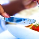 woman-cutting-food-on-plate