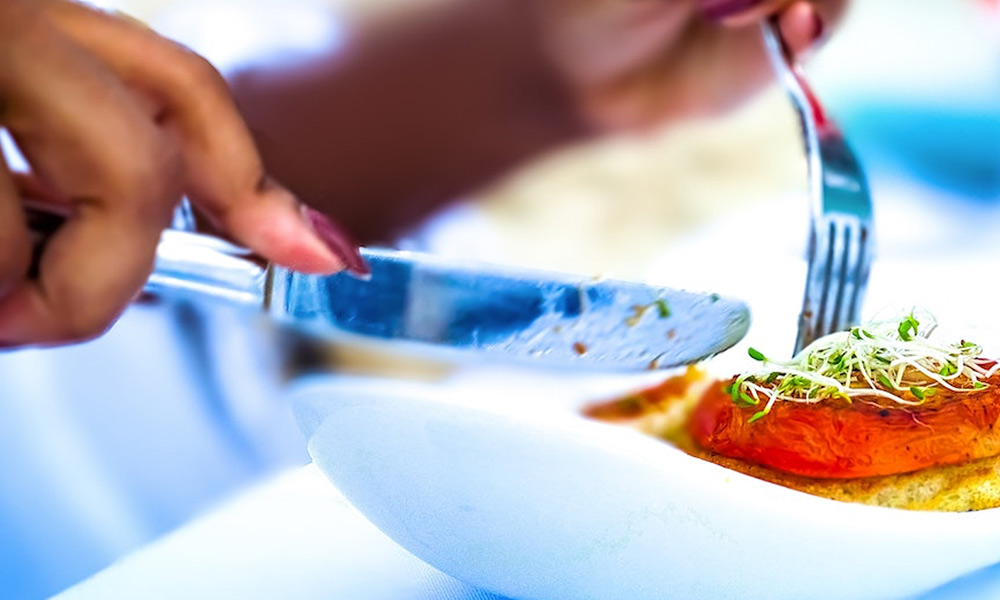 woman-cutting-food-on-plate