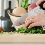 person cutting vegetables preparing healthy meals