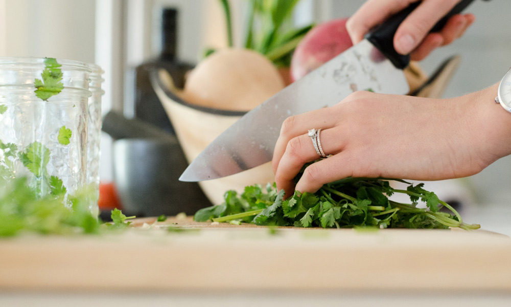 person cutting vegetables preparing healthy meals